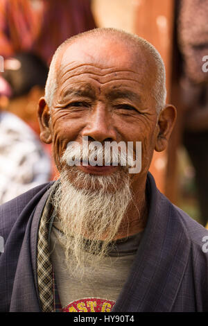 Ein älterer bhutanischen Mann in der traditionellen Gho Robe auf dem freien Markt in Punakha, Bhutan. Stockfoto