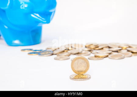 eine blaue Kunststoff-Sparschwein mit Euro-Münzen Stockfoto