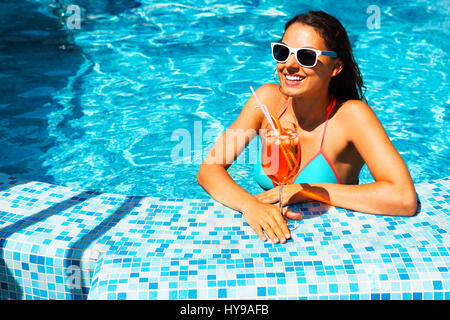 Echte weibliche Schönheit genießen ihre Sommerferien am Pool mit Alkohol cocktail Stockfoto