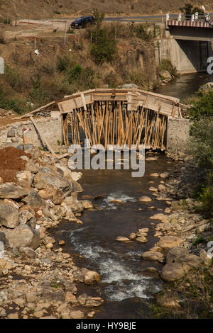 Eine neue Brücke über einen Bach befindet sich im Aufbau, in der Nähe von Sopsokha, Bhutan.  Holzstützen haben unter den konkreten Formen gelegt. Stockfoto