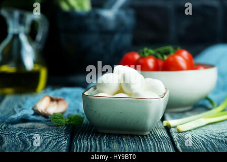 Mozzarella in Schüssel geben und auf einem Tisch Stockfoto