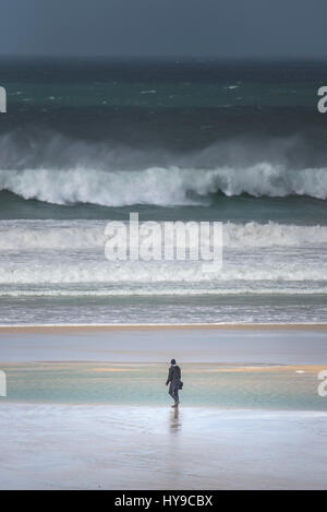 Mann zu Fuß Spaziergang bummeln Strand Ufer Küste am Meer Meer Wellen Surf rauen windigen stürmischen Spray atmosphärischen Fistral Cornwall Stockfoto