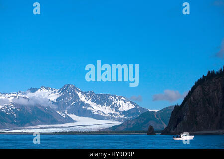 Ein Boot im Vordergrund einer Landschaft mit Bear Glacier in Kenai Fjords Nationalpark in der Nähe von Seward, Alaska. Stockfoto