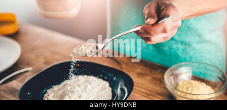 Frau Gießen Semmelbröseln im bis auf den Teller Stockfoto