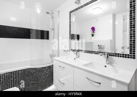 Schwarz / weiß-Luxus-Badezimmer mit Mosaik-Fliesen, Badewanne und Spiegel Stockfoto