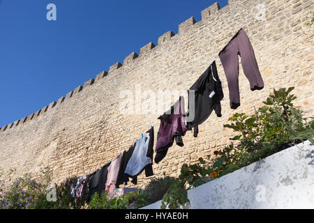 Óbidos, Portugal: Wäsche zum Trocknen entlang der mittelalterlichen Stadtmauer des alten Dorfes aufgehängt. Stockfoto