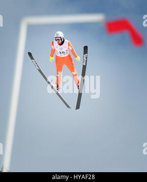 Team Kanada Skispringer Mackenzie Boyd-Clowes ist eingerahmt von einer Windfahne wie er von der Großschanze Sprung im Whistler Olympic Park während der 2017 fliegt Stockfoto