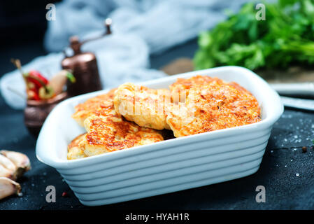gebratene Schnitzel in Schüssel geben und auf einem Tisch Stockfoto