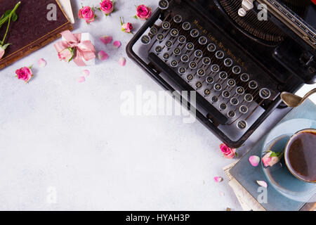 Arbeitsbereich mit Vintage Schreibmaschine, Kaffee und Bücher Stockfoto