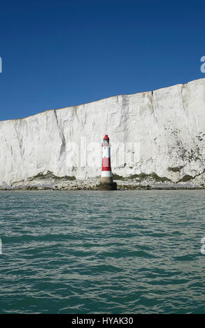 England, East Sussex, Beachy Head, rot und weiß lackiert Leuchtturm am Fuße des Felsen. Stockfoto