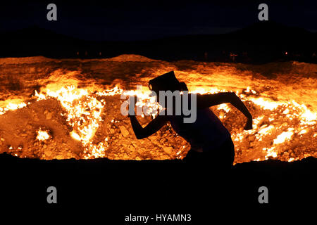 DERWEZE, TURKMENISTAN: Honeymooner Helen Melville-Kenney machen Unfug am Tor zur Hölle. Diese britische Flitterwochen gezogen buchstäblich gegenseitig zur Hölle. Ingenieur Neil (34) und seine Braut Helen Melville-Kenney (36) nahm, als sie beschlossen, ihre neue Ehe zu feiern, fährt man 3.000 Meilen aus dem Vereinigten Königreich nach dem wirklichen Leben 230-Füße weit vom Menschen verursachten Krater in den Flitterwochen in einem heißen Ort zum nächsten Level. Sie fuhren in einem Fiat Panda namens Charlie. Bei der Ankunft das glückliche Paar zu sehen sein flamin' viel Spaß, mit anderen Besuchern zum Derweze Gas Krater, bekannt als das Tor zur Hölle Stockfoto