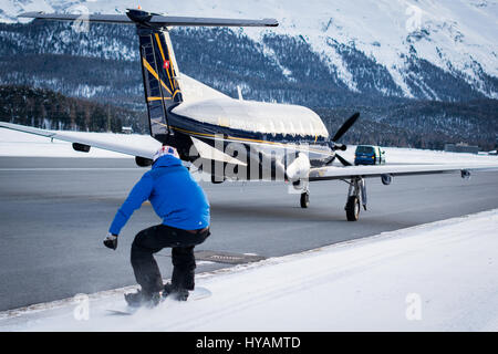 ENGADIN AIRPORT, Schweiz: Eine britische Snowboarder erreicht Geschwindigkeiten von 78 Meilen pro Stunde und wurde die erste Person zum snowboard Weile von einem kommerziellen Flugzeug geschleppt werden. Waghalsige Jamie Barrow (22) von der britischen Snowboard Cross Team ist Großbritanniens am schnellsten Snowboarder und unglaubliche Stunts durch Erhängen von der Tragfläche eines Flugzeugs Engadin Airport in der Schweiz abgeschlossen. Bilder zeigen wie Jamie gekonnt auf den verschneiten Rand der Start-und Landebahn, trotz der hektischen Tempo erklettert, die das Flugzeug unterwegs war. Stockfoto