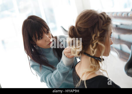 Kiew, Ukraine - 3. März 2017: Closeup Friseur Coiffeur macht Frisur. Schöne Frau mit Friseur im Salon. Stockfoto