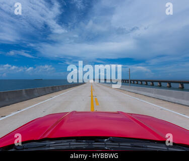 Rotes Auto fahren auf der Mitte einer Brücke in Florida, USA Stockfoto