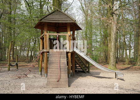 Waldspielplatz mit Holzhütte und Rutsche Stockfoto