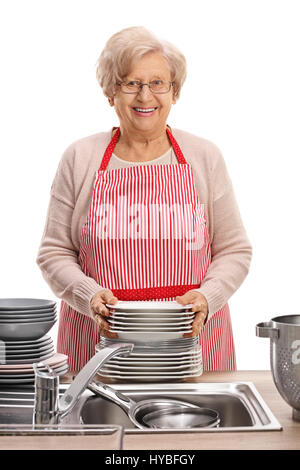 Glücklich Reife Frau mit einem Stack von sauberen Tellern isoliert auf weißem Hintergrund Stockfoto