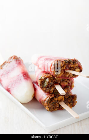 Hausgemachte Berry und Karamell Müsli-Eis-Pops auf weißen Teller Stockfoto