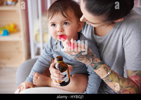 Mutter Fütterung junge mit Medizin Stockfoto