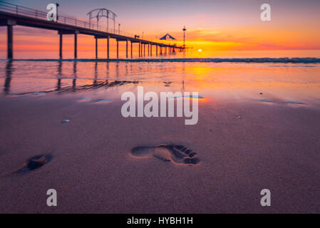 Menschliche Spuren im nassen Sand bei Sonnenuntergang, South Australia Stockfoto