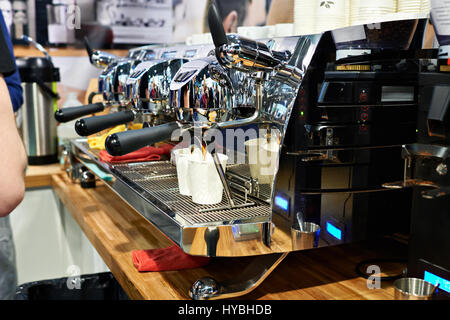 Große Kaffeemaschine gießt zwei Pappbecher im café Stockfoto