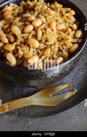 Vollkorn-Reis mit Gartenbohnen oder weiße Bohnen und Quinoa in einem japanischen braun Keramik Schale gesund hoch in Faser-Alternative zu weißem Reis Stockfoto