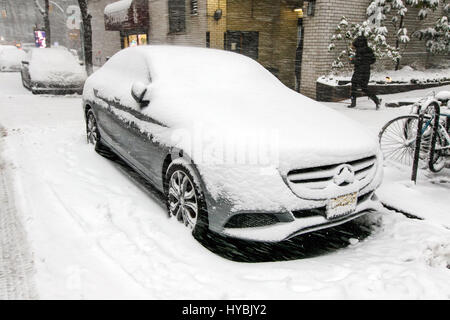 Schnee sammelt sich auf dem Boden und auf Fahrzeuge wie dieses geparkten Mercedes Benz während einem Schneefall. Stockfoto