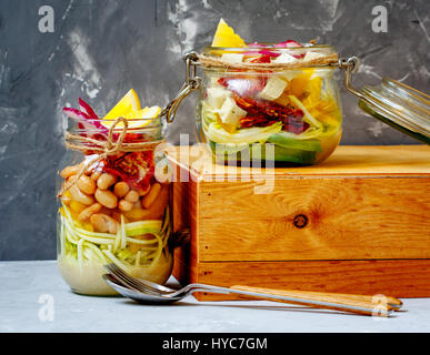 Hausgemachte Glas Zucchini Nudeln mit Tofu, Bohnen und Gemüse. Detox Diät, vegetarisch, Vegan, sauber essen Food-Konzept. Dunkelgrauen Hintergrund, selec Stockfoto