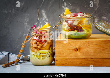 Hausgemachte Glas Zucchini Nudeln mit Tofu, Bohnen und Gemüse. Detox Diät, vegetarisch, Vegan, sauber essen Food-Konzept. Dunkelgrauen Hintergrund, selec Stockfoto