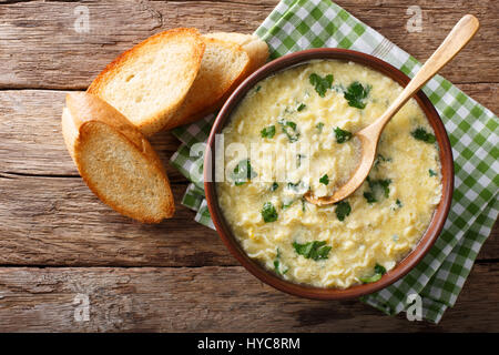 Italienische Ei Suppe Stracciatella mit Pasta und Parmesan Nahaufnahme Farfalline in eine Schüssel geben. horizontale Ansicht von oben Stockfoto