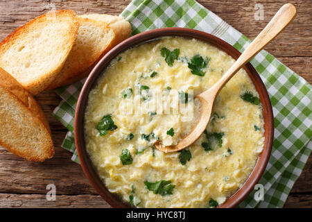 Italienische Küche: Suppe Stracciatella mit Nahaufnahme von Farfalline und Käse in eine Schüssel geben. horizontale Ansicht von oben Stockfoto