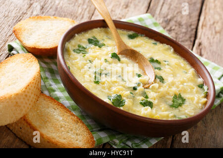 Kinder Ei-Creme Suppe Stracciatella mit Nahaufnahme von Farfalline und Käse in eine Schüssel geben. horizontale Stockfoto