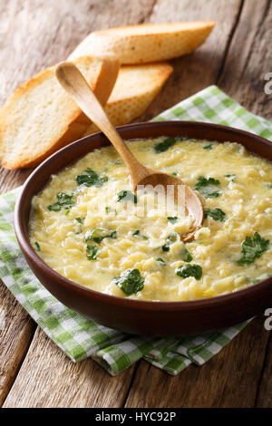 Leckeres Ei Stracciatella mit Nudeln und Käse Nahaufnahme Farfalline in eine Schüssel geben. vertikale Stockfoto