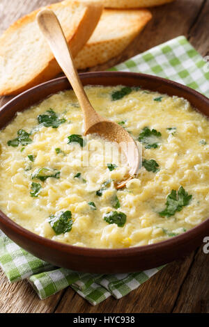 Italienische Ei Suppe Stracciatella mit Pasta und Parmesan Nahaufnahme Farfalline in eine Schüssel geben. vertikale Stockfoto