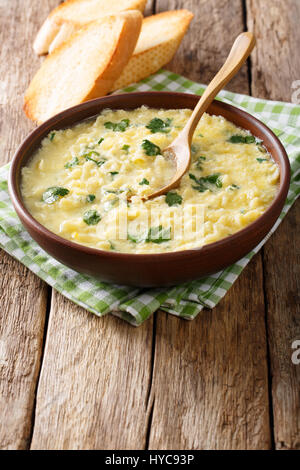 Italienische Ei Suppe Stracciatella mit Farfalline Nudeln Nahaufnahme in eine Schüssel geben. vertikale Stockfoto