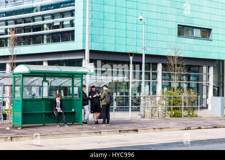 Studenten warten auf einen Bus außerhalb des Campus der Nantgarw von Coleg y Cymoedd, (Hochschule der Täler), eine Weiterbildung College, Mid Glamorgan, Wales Stockfoto