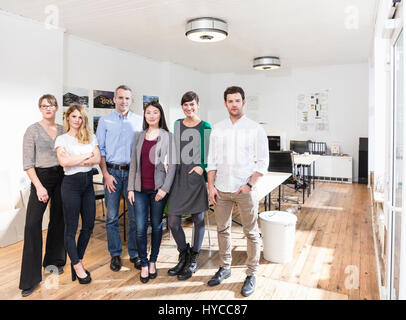 Voller Länge Ansicht des Kollegen nebeneinander im Büro Blick auf die Kamera zu Lächeln Stockfoto