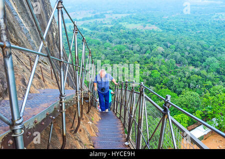 Die Touristen Klettern Sigiriya Festung, mit schmalen Wendeltreppe entlang den steilen Hang des Felsens, Sri Lanka. Stockfoto