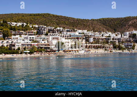 Menschen schwimmen in Icmeler Beach in der Nähe von Bodrum Stadtzentrum entfernt. Es ist ein sonniger Sommertag. Traditionelle, weißen, typischen Sommerhäuser reflektieren Region Architektur Stockfoto