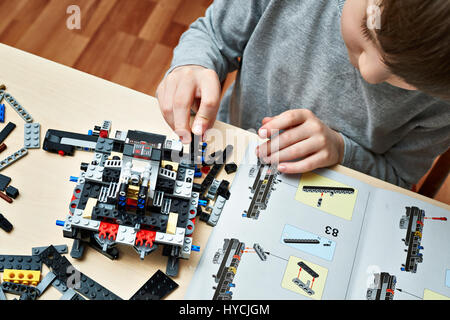 Kleiner Junge spielt und sammelt die Kinderspielzeug aus Kunststoff Stockfoto