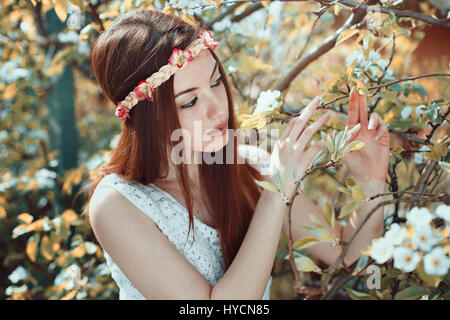 Junge Frau in einem blühenden Obstgarten. Saisonale Frühling Stockfoto