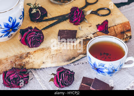 Tasse Tea.with trockenen Rosen Knospen und Schokolade. Stockfoto