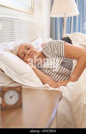 Ältere Frau schlief in ihrem Bett in den Morgen Stockfoto