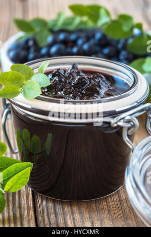 Blaubeeren Marmelade im Glas auf Holztisch und frischen Beeren. Hausgemachten Marmeladen Stockfoto