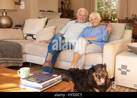 Gerne älteres Paar mit ihrem Hund zu Hause entspannen Stockfoto