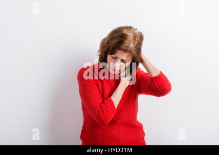 Ältere Frau Kopf haltend, mit Kopfschmerzen. Studio gedreht. Stockfoto