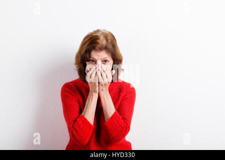 Ältere Frau Kopf haltend, mit Kopfschmerzen. Studio gedreht. Stockfoto