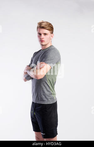 Gut aussehender Mann im grauen T-shirt tattoo auf Unterarme, Studio gedreht. Stockfoto