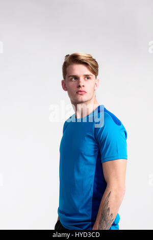 Junge hübsche Hipster Mann in blau Sport T-shirt, Studio gedreht. Stockfoto