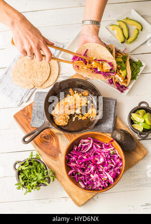 Frau, die Tortilla mit Tilapia und Rotkohl vorbereitet Stockfoto