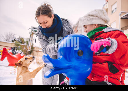 Mutter und Tochter auf Schnee überdachten Spielplatz Spaß haben Stockfoto